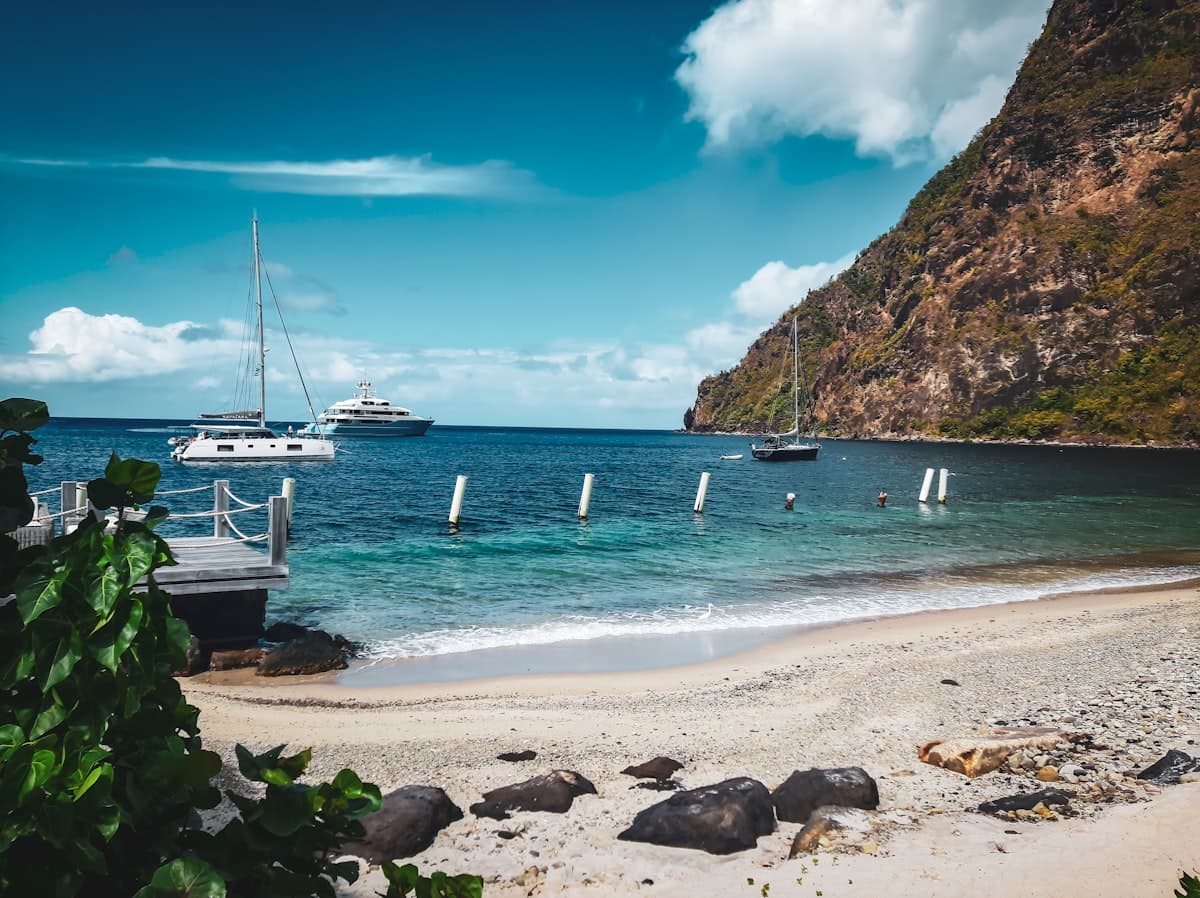 Sailboats anchored in a calm St. Lucia bay beneath a green mountain
