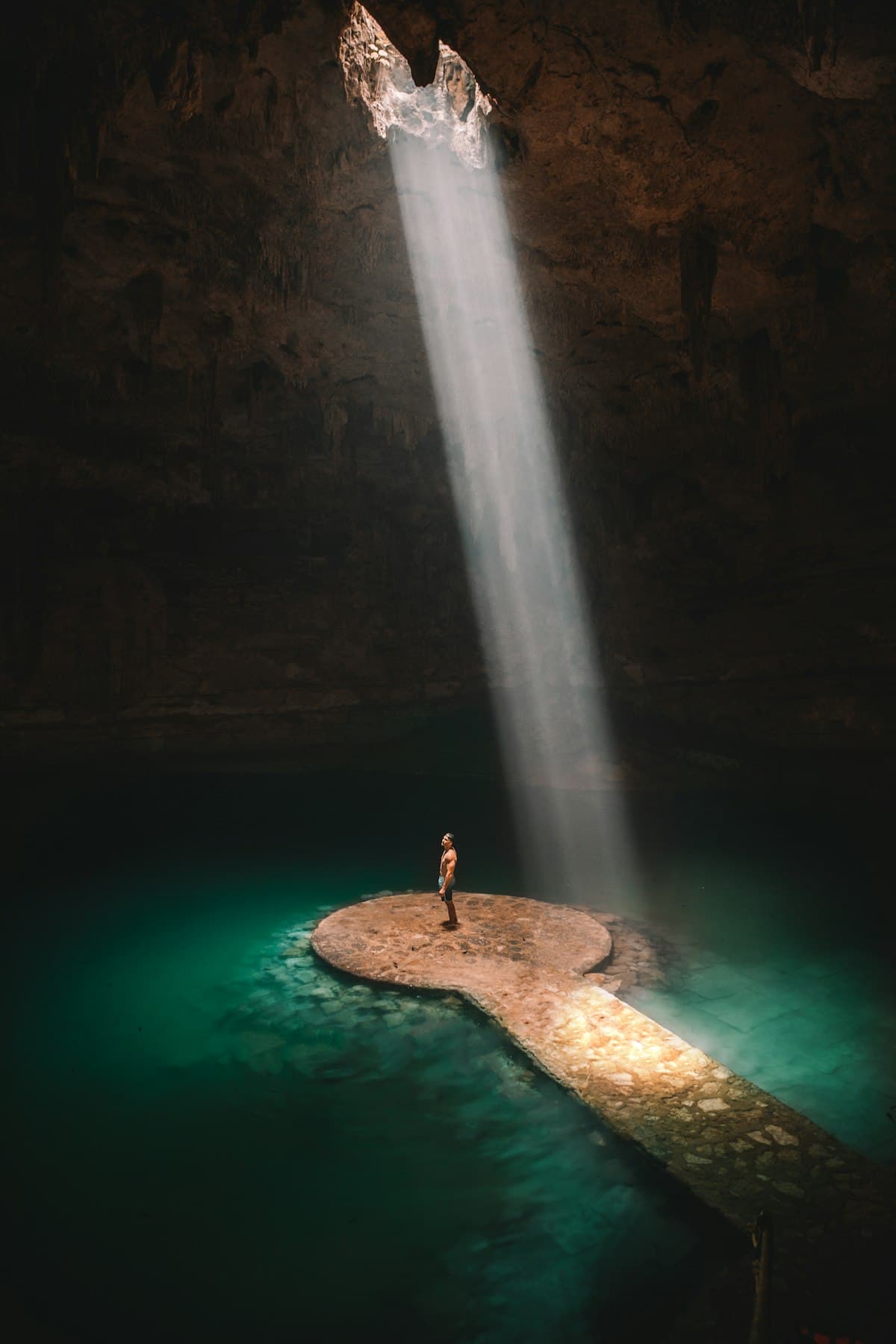 A shaft of light falling into a jungle cenote in Mexico